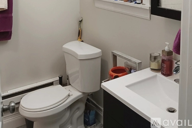 A white toilet sits next to a white sink in a small bathroom.