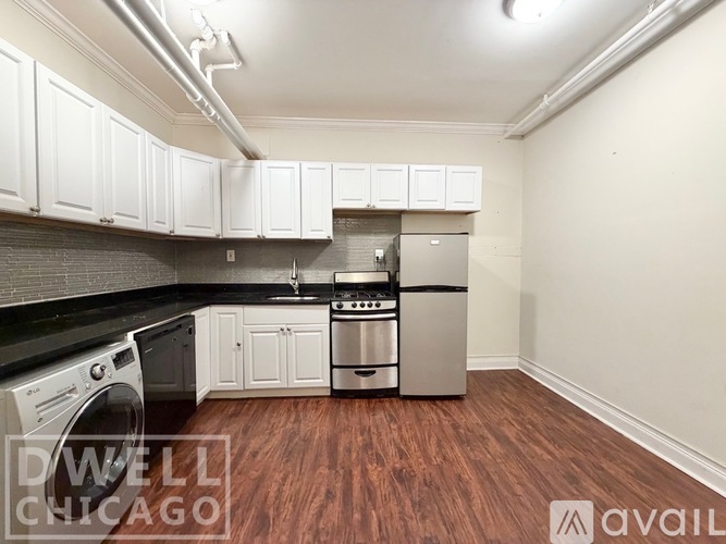 A kitchen with white cabinets and a black counter top.