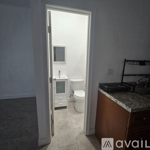 A bathroom with a toilet, sink, and cabinet.