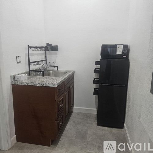 A kitchen with a black fridge and a brown counter.