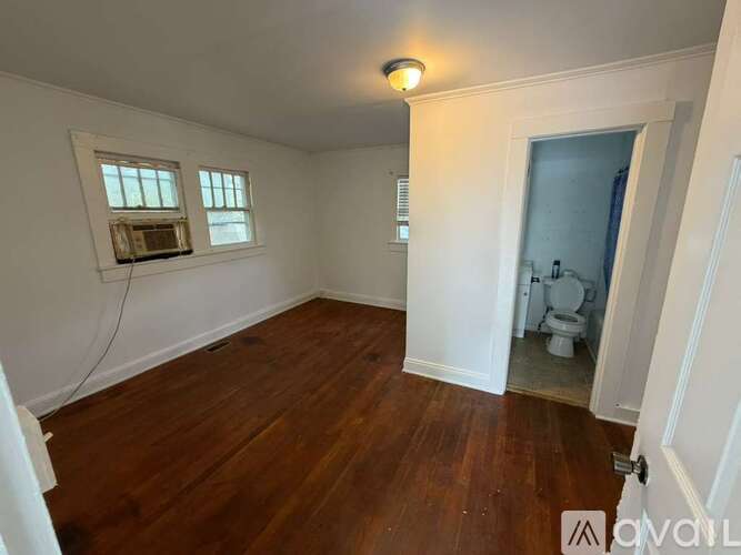 A room with wooden floors and a window with a white frame.