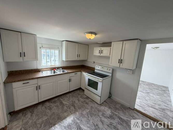 A kitchen with white cabinets and a granite countertop.
