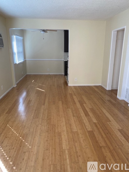 A room with wooden flooring and a ceiling fan.