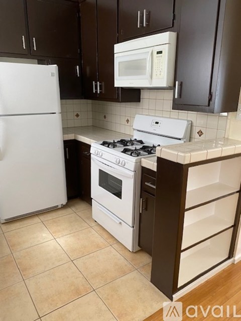 A kitchen with a white refrigerator and a white stove top oven.