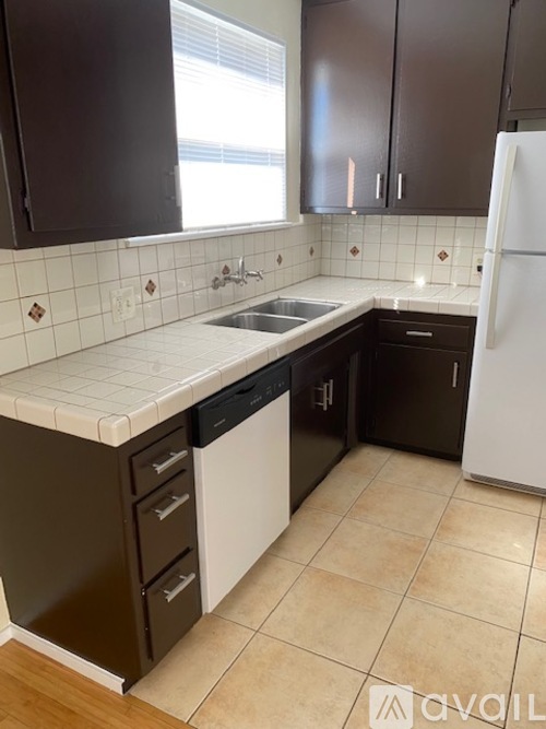A kitchen with brown cabinets and a white fridge.