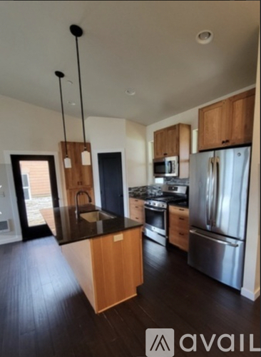 A kitchen with wooden cabinets and a black countertop.