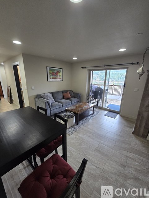 A spacious room with a long hallway leading to a sliding glass door.