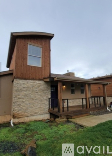 A house with a brown wooden exterior and a stone wall.