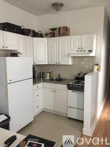 A kitchen with white cabinets and appliances.