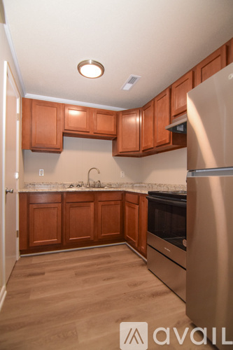 A kitchen with wooden cabinets and a stainless steel refrigerator.
