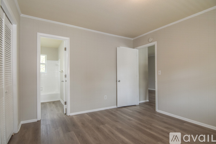 A room with wooden floors and two white doors.