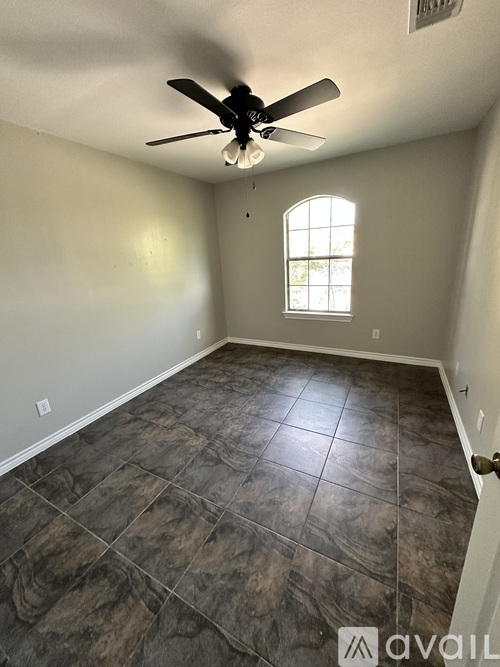 A room with a ceiling fan and a window.