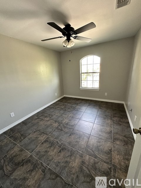 A room with a ceiling fan and a window.