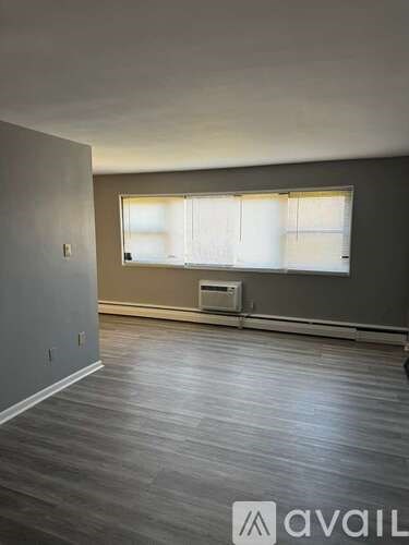 A room with a window and a wall-mounted air conditioner unit.