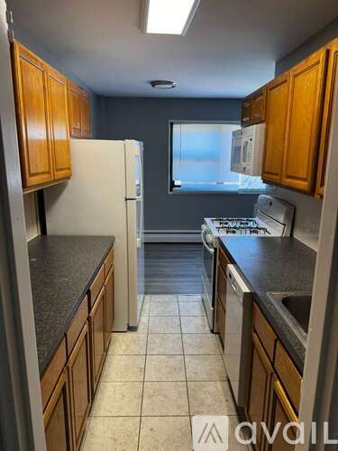 A kitchen with wooden cabinets and a white refrigerator.