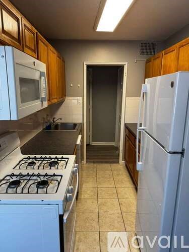 A kitchen with a white fridge, white stove and white dishwasher.