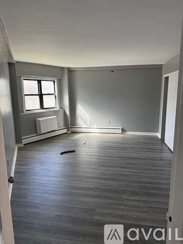 A room with wooden flooring and a window.