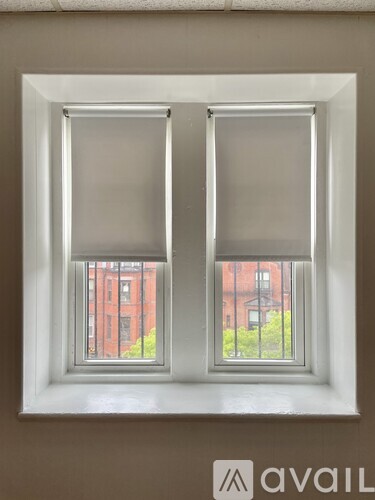 A window with two panes of glass, one of which has a blind.