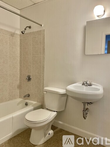 A white toilet sits next to a white sink in a bathroom.