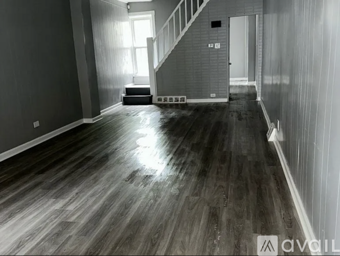 A room with wooden floors and a staircase.