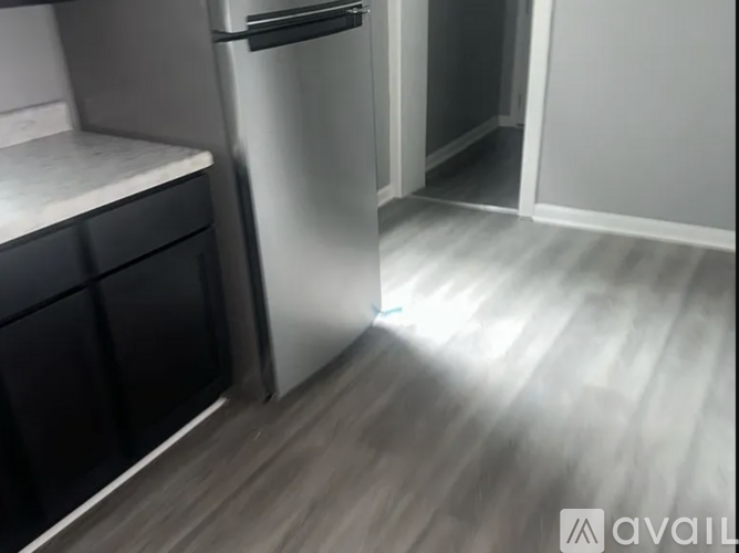 A kitchen with a refrigerator and a drawer.