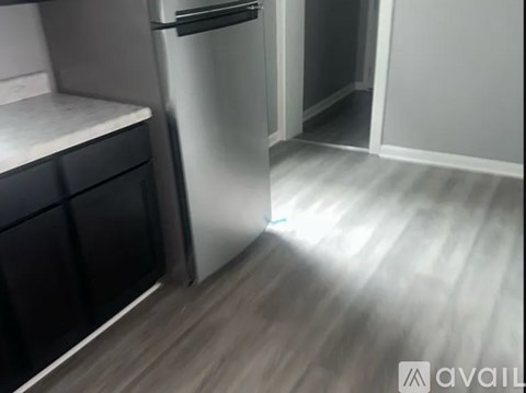 A kitchen with a refrigerator and a drawer.