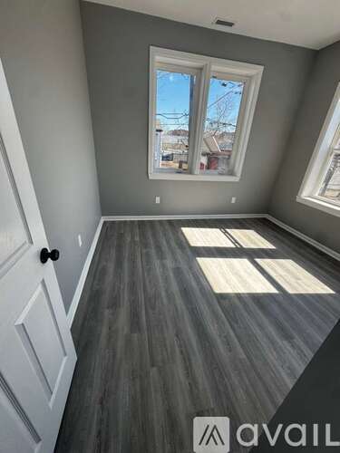 A room with grey walls and a window with a view of the outside.
