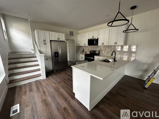 A kitchen with white cabinets and a wooden floor.