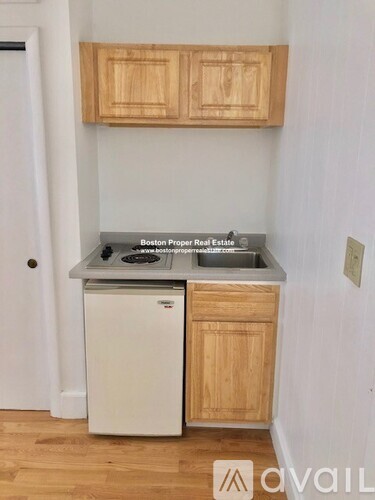 A kitchen with wooden cabinets and a white dishwasher.