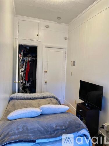 A bedroom with a bed, a wardrobe, and a television.