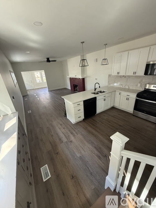 A large open kitchen and living room with wood floors and white cabinetry.