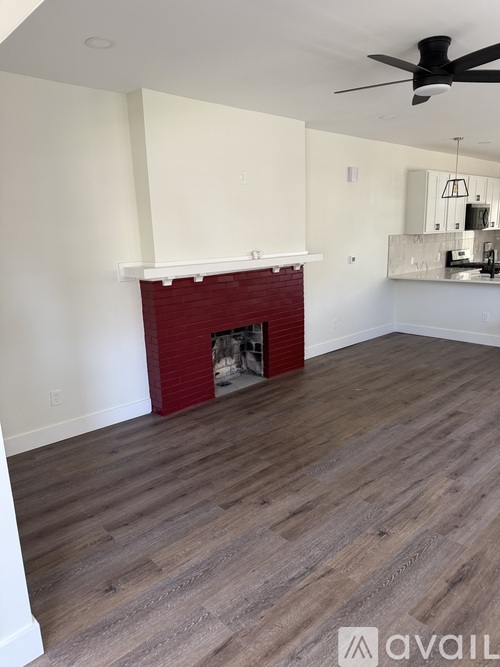 A room with a fireplace and a ceiling fan.