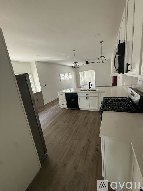 A kitchen with white cabinets and a black countertop.