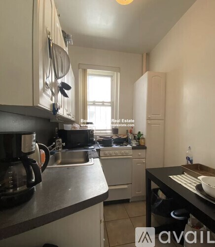 A kitchen with a sink, stove, and a window.