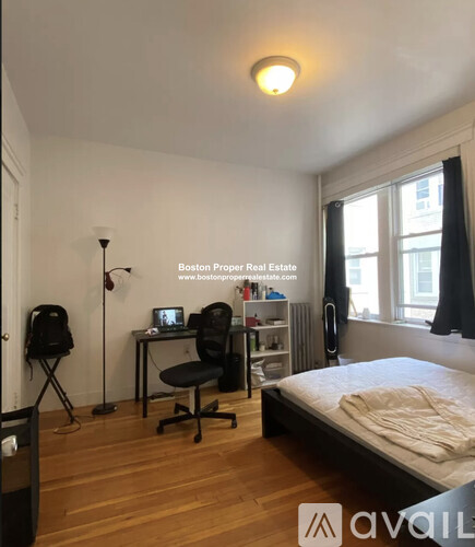 A bedroom with a bed, desk, and chair.