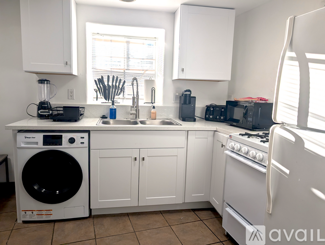 A kitchen with white appliances and cabinets.
