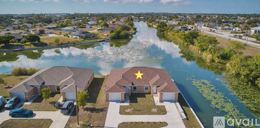 A house with a yellow star on the roof is located near a river.