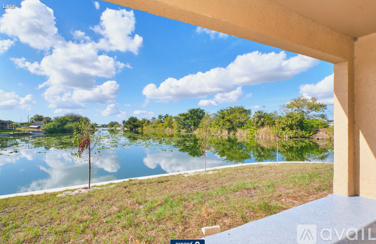 A view from a balcony overlooking a lake and trees.