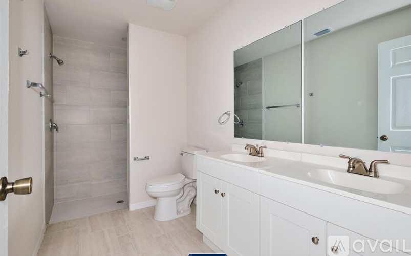 A white bathroom with a toilet, sink, and shower.