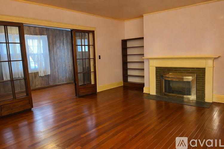 A room with a fireplace and wooden floors.