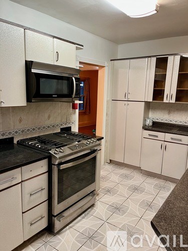 A kitchen with a black stove top oven and a microwave above it.