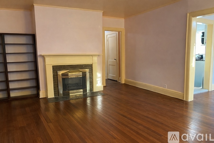A room with a fireplace and wooden floors.