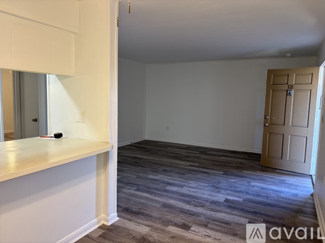 A room with a wooden floor and a door with the number 12 on it.