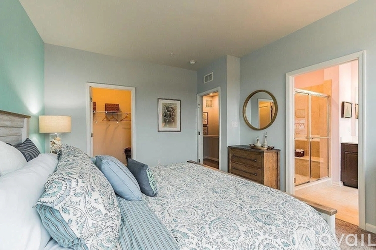A bedroom with a large bed and a mirror on the wall.