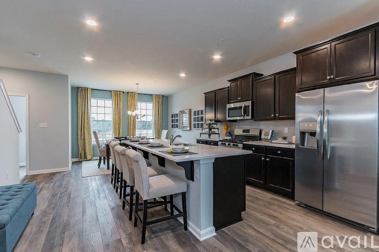 A modern kitchen with dark wood cabinets and stainless steel appliances.