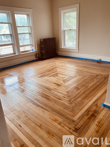 A room with wooden flooring and a radiator.