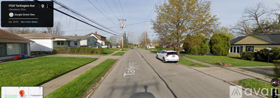 A car is driving down a street with houses on both sides.