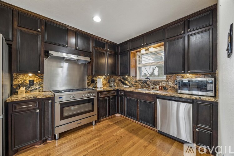 A kitchen with dark wood cabinets and stainless steel appliances.