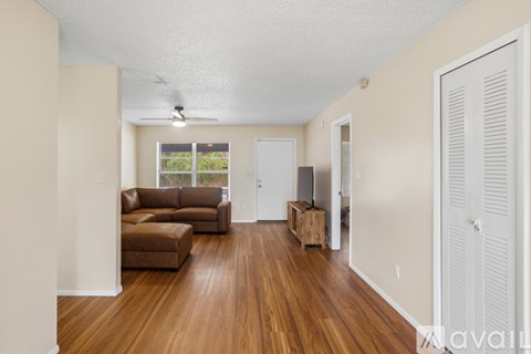 A living room with a brown couch and a wooden floor.
