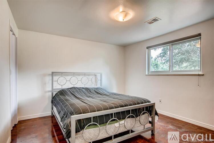 A bedroom with a large bed and a window.